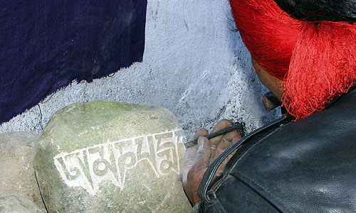 チベット文字を石に刻み込み職人さん。彫った後鮮やかな色彩がペイントされる「マニ石」